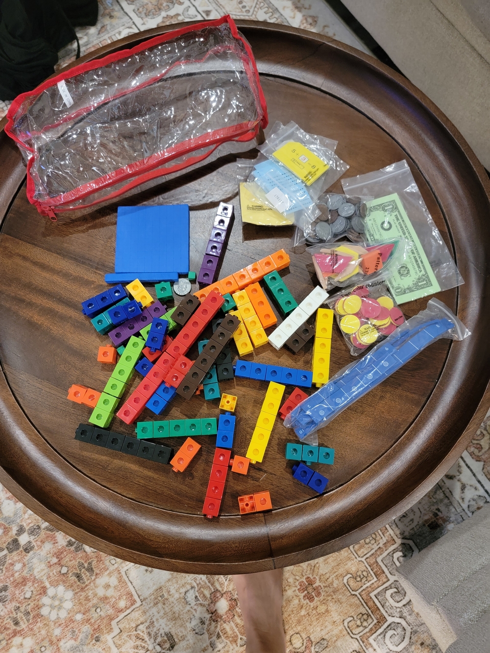 Math manipulatives, including colorful linking cubes and Play Money
